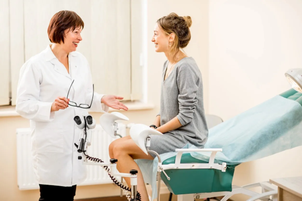 A-doctor-speaks-with-a-patient-during-a-gynecological-appointment-in-a-clinic-exam-room.png